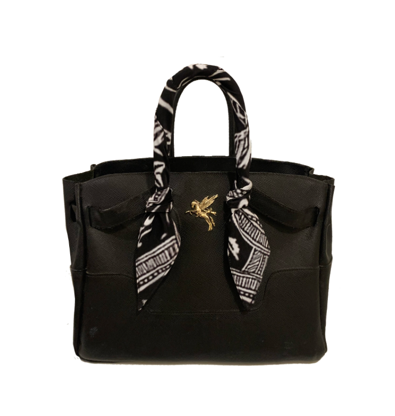Black leather handbag facing front with gold hardware. This bag has top handles and adjustable sizes. the handbag is handmade in Boston Massachusetts. The logo. is Bellerophon on the back of pegasus rearing. This bag has. a black and white mosaic pattern scarf wrapped around the handles, giving this a luxurious and elevated style that is timeless. 